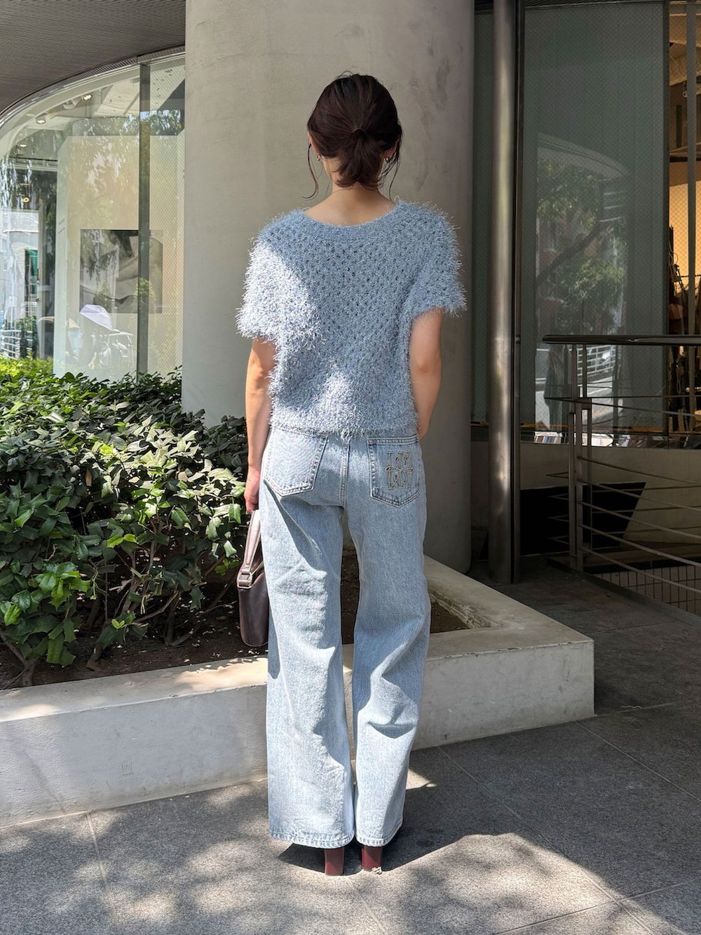 レッド系のブーツ、ブルー系のデニムパンツ、ブルー系のニット/セーターを着用したレディースの夏コーディネートの3枚目の写真