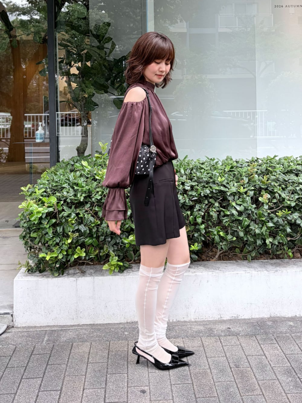 ブラック系のハンドバッグ、ブラック系のその他パンツ、ブラウン系のシャツ/ブラウスを着用したレディースの秋コーディネートの3枚目の写真