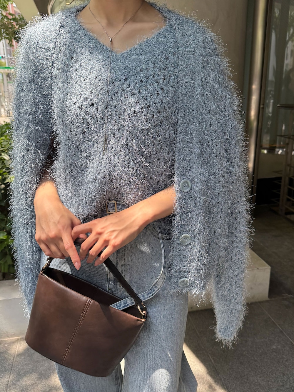 レッド系のブーツ、ブルー系のデニムパンツ、ブルー系のニット/セーターを着用したレディースの夏コーディネートの5枚目の写真