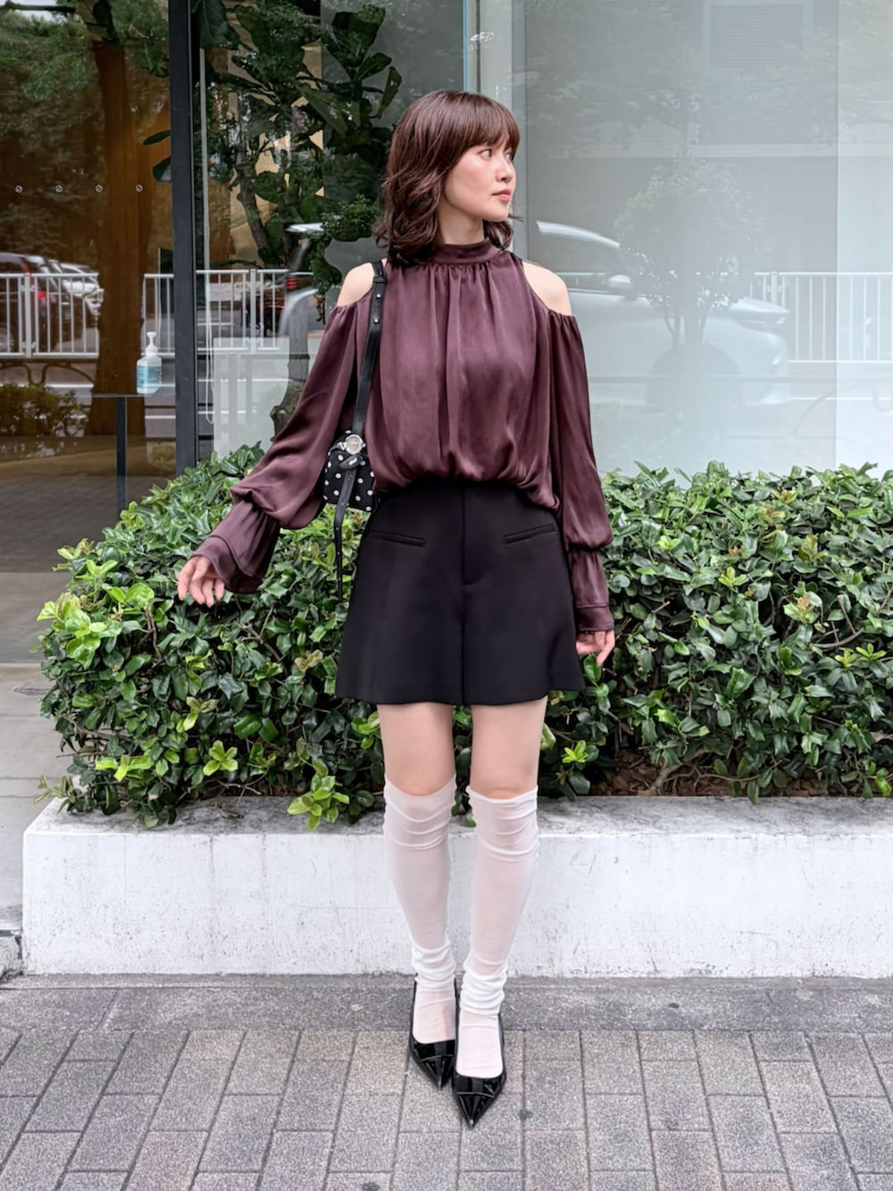 ブラック系のハンドバッグ、ブラック系のその他パンツ、ブラウン系のシャツ/ブラウスを着用したレディースの秋コーディネートの2枚目の写真