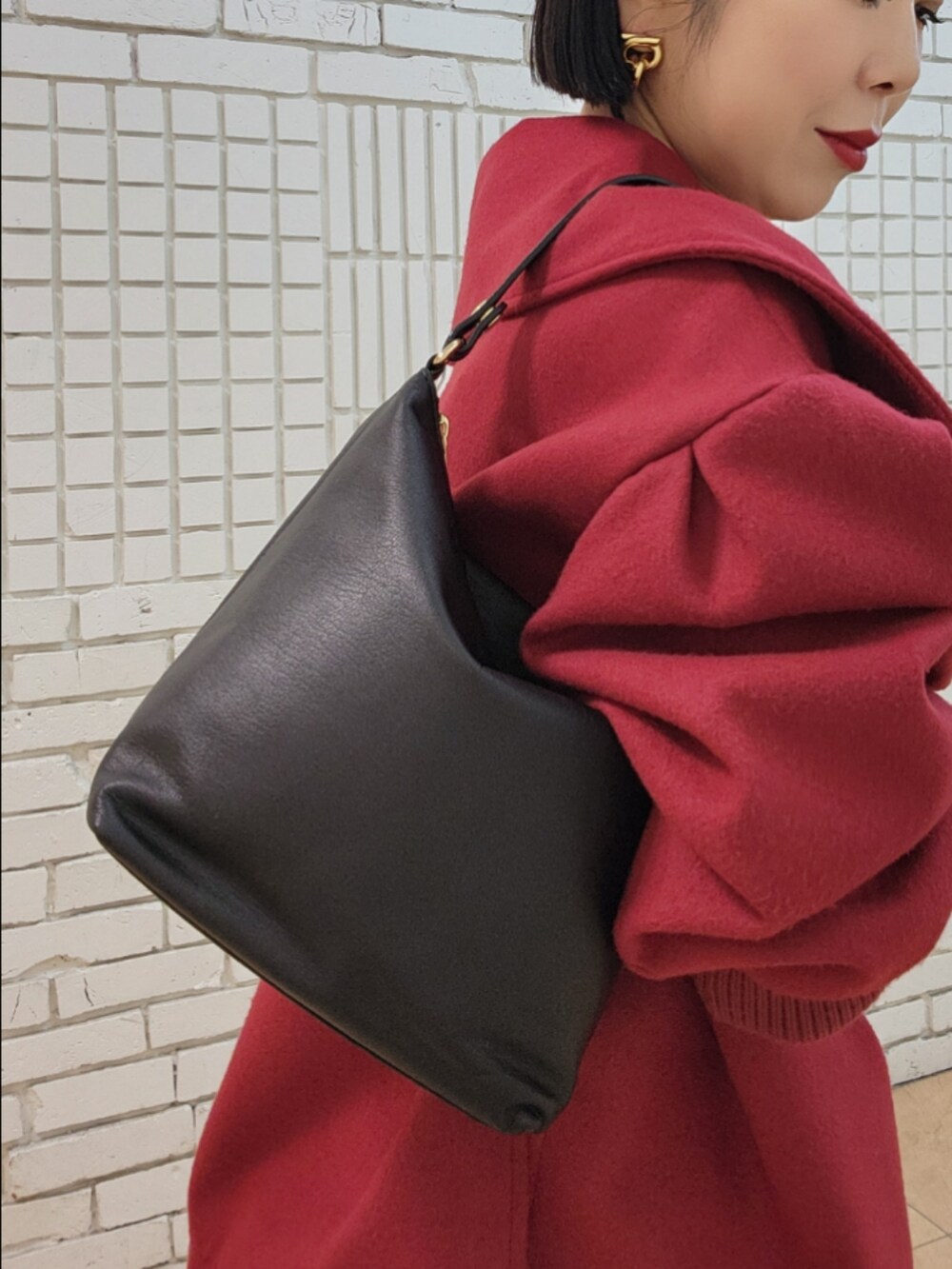 ブラック系のショルダーバッグを着用したレディースの秋コーディネートの2枚目の写真