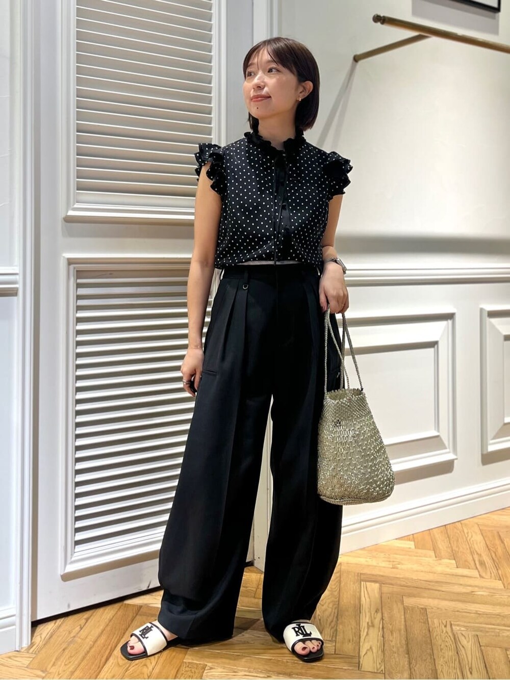 ブラック系のシャツ/ブラウス、ブラック系のその他パンツ、シルバー系のトートバッグを着用したレディースの春コーディネートの2枚目の写真