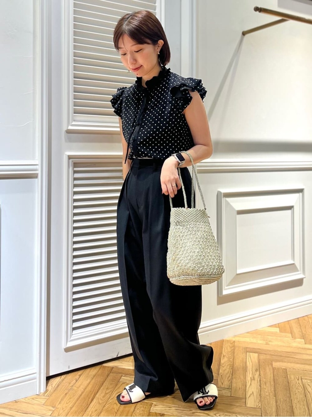 ブラック系のシャツ/ブラウス、ブラック系のその他パンツ、シルバー系のトートバッグを着用したレディースの春コーディネートの6枚目の写真