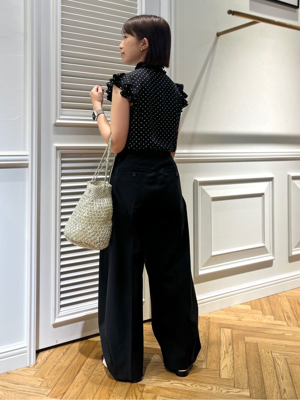 ブラック系のシャツ/ブラウス、ブラック系のその他パンツ、シルバー系のトートバッグを着用したレディースの春コーディネートの4枚目の写真
