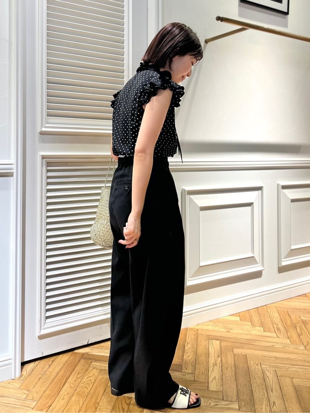 ブラック系のシャツ/ブラウス、ブラック系のその他パンツ、シルバー系のトートバッグを着用したレディースの春コーディネートの5枚目の写真