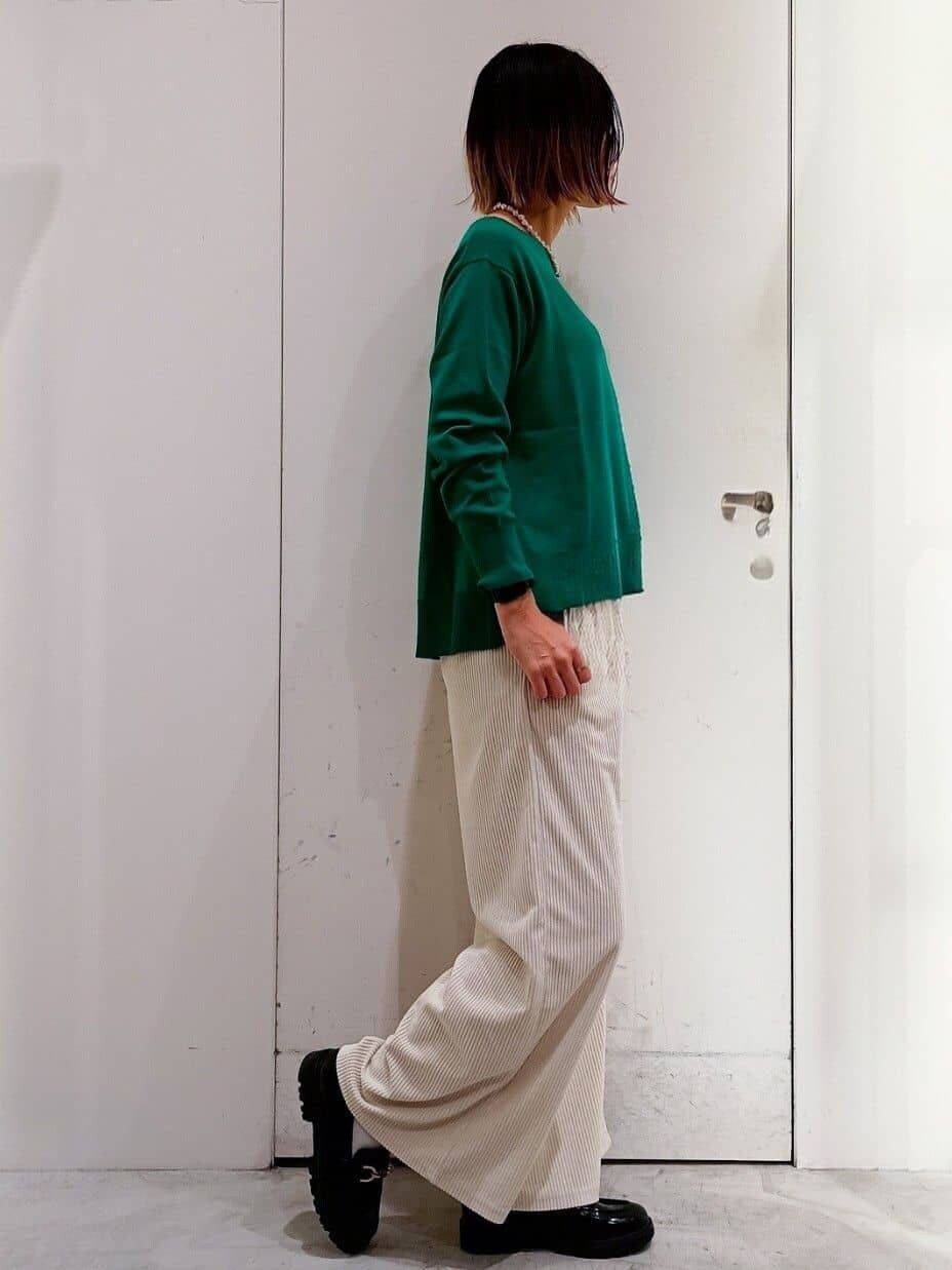 グリーン系のニット/セーター、ホワイト系のその他パンツ、ホワイト系のトートバッグを着用したレディースの冬コーディネートの2枚目の写真