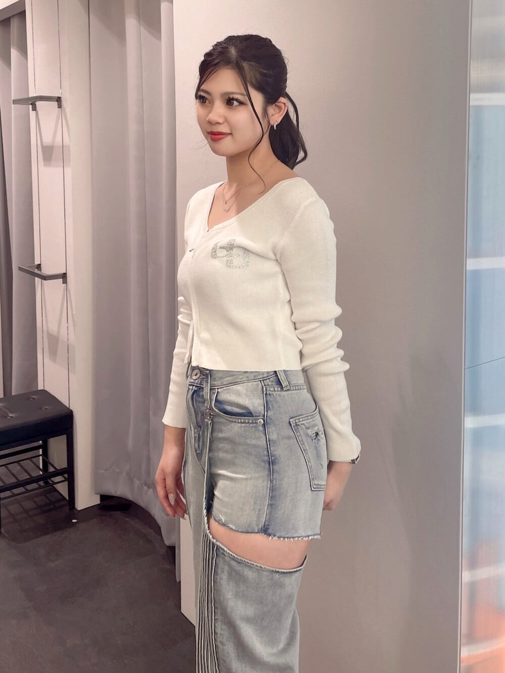 ブラック系のブーツ、ホワイト系のニット/セーター、ブルー系のデニムパンツを着用したレディースの春コーディネートの5枚目の写真