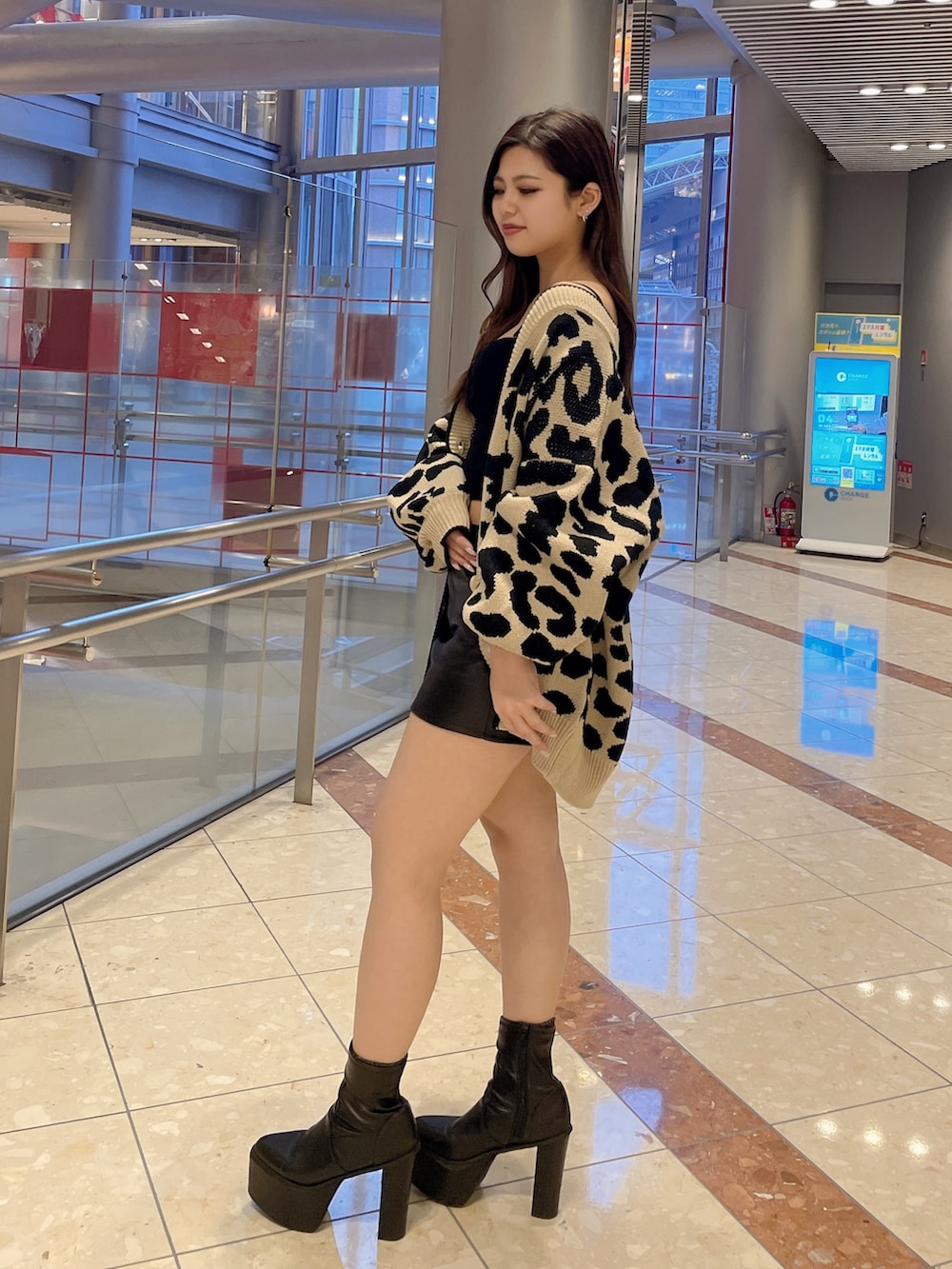 ブラック系のスカート、ホワイト系のキャミソール、ベージュ系のカーディガン/ボレロを着用したレディースの春コーディネートの2枚目の写真