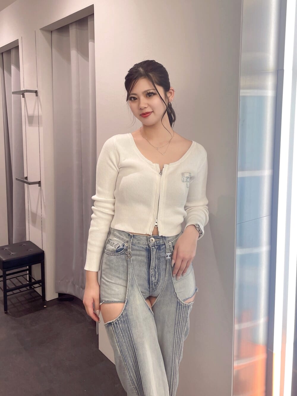 ブラック系のブーツ、ホワイト系のニット/セーター、ブルー系のデニムパンツを着用したレディースの春コーディネートの4枚目の写真