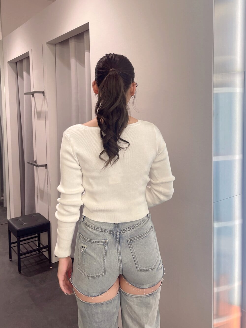 ブラック系のブーツ、ホワイト系のニット/セーター、ブルー系のデニムパンツを着用したレディースの春コーディネートの6枚目の写真