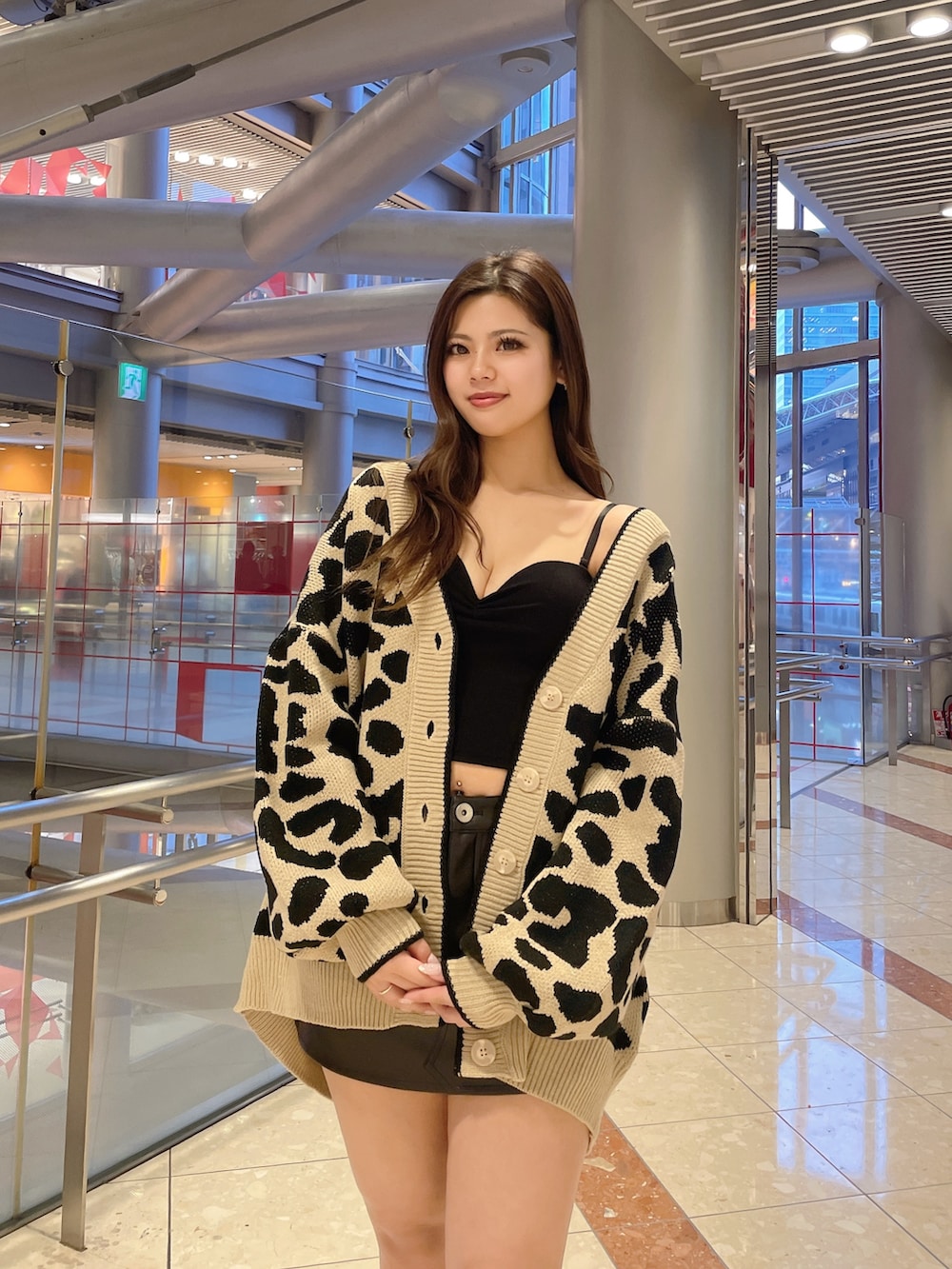 ブラック系のスカート、ホワイト系のキャミソール、ベージュ系のカーディガン/ボレロを着用したレディースの春コーディネートの4枚目の写真