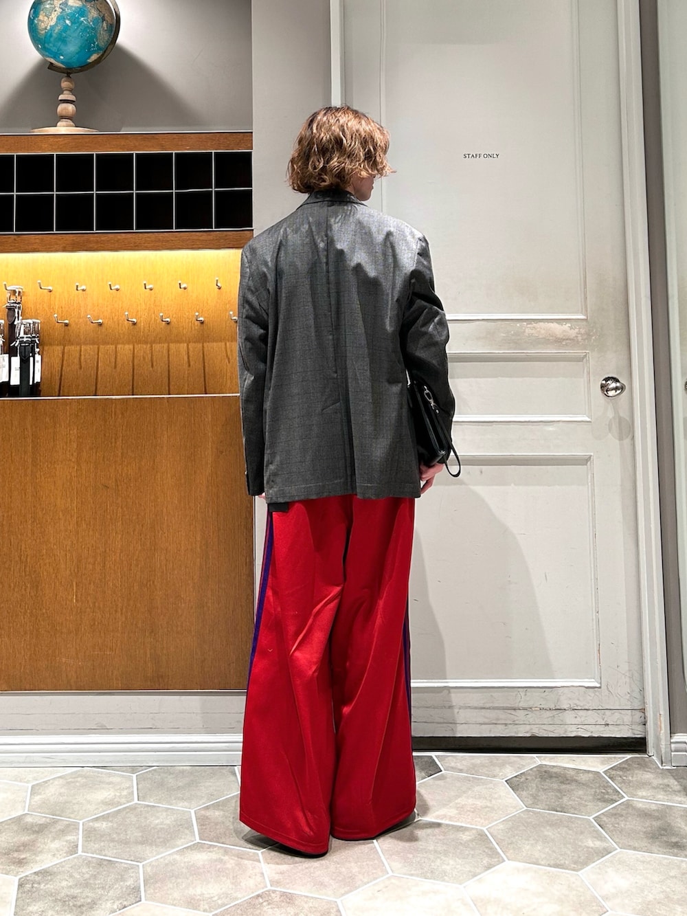 ブラック系のブーツ、レッド系のパンツを着用したメンズの春コーディネートの3枚目の写真