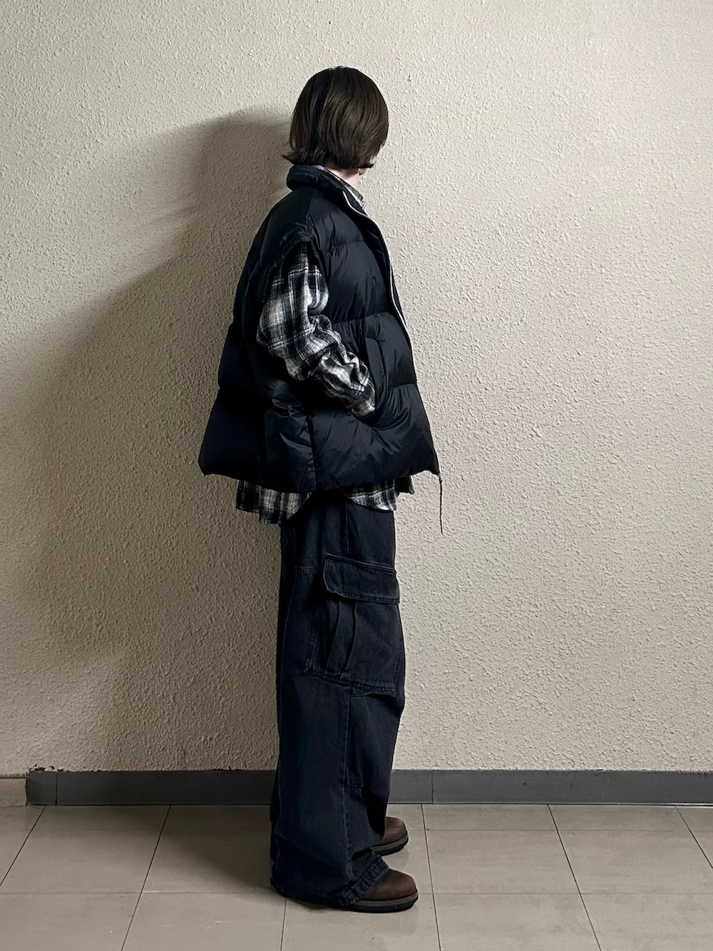 ブラック系のカーゴパンツ、ブラック系のダウンベスト、ブラウン系のブーツを着用したメンズの春コーディネートの2枚目の写真