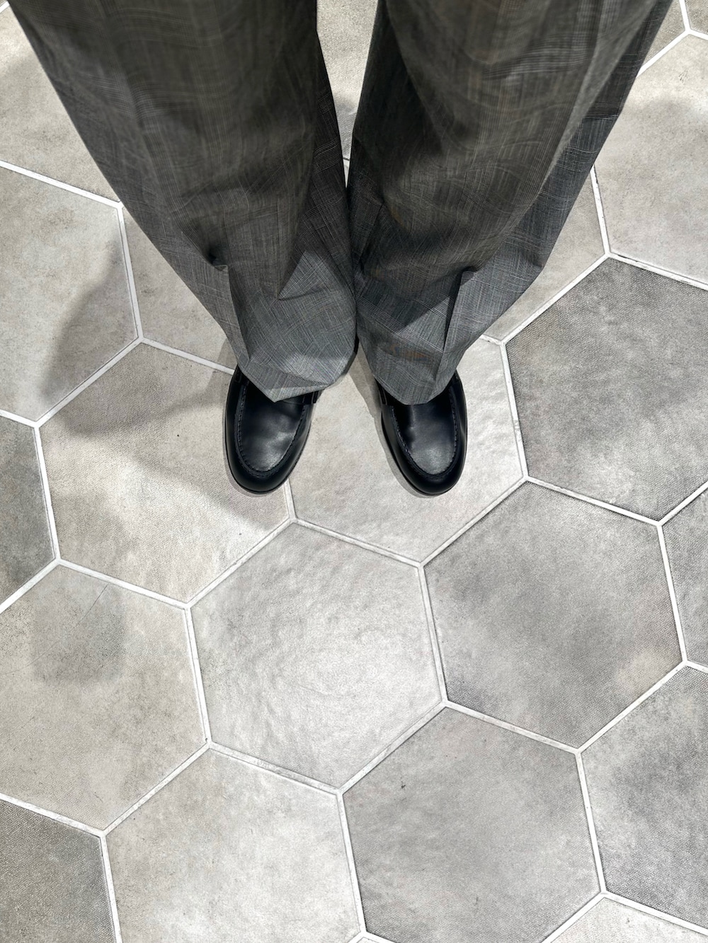 レッド系のニット/セーター、ブルー系のブルゾン、グレー系のスラックスを着用したメンズの春コーディネートの5枚目の写真