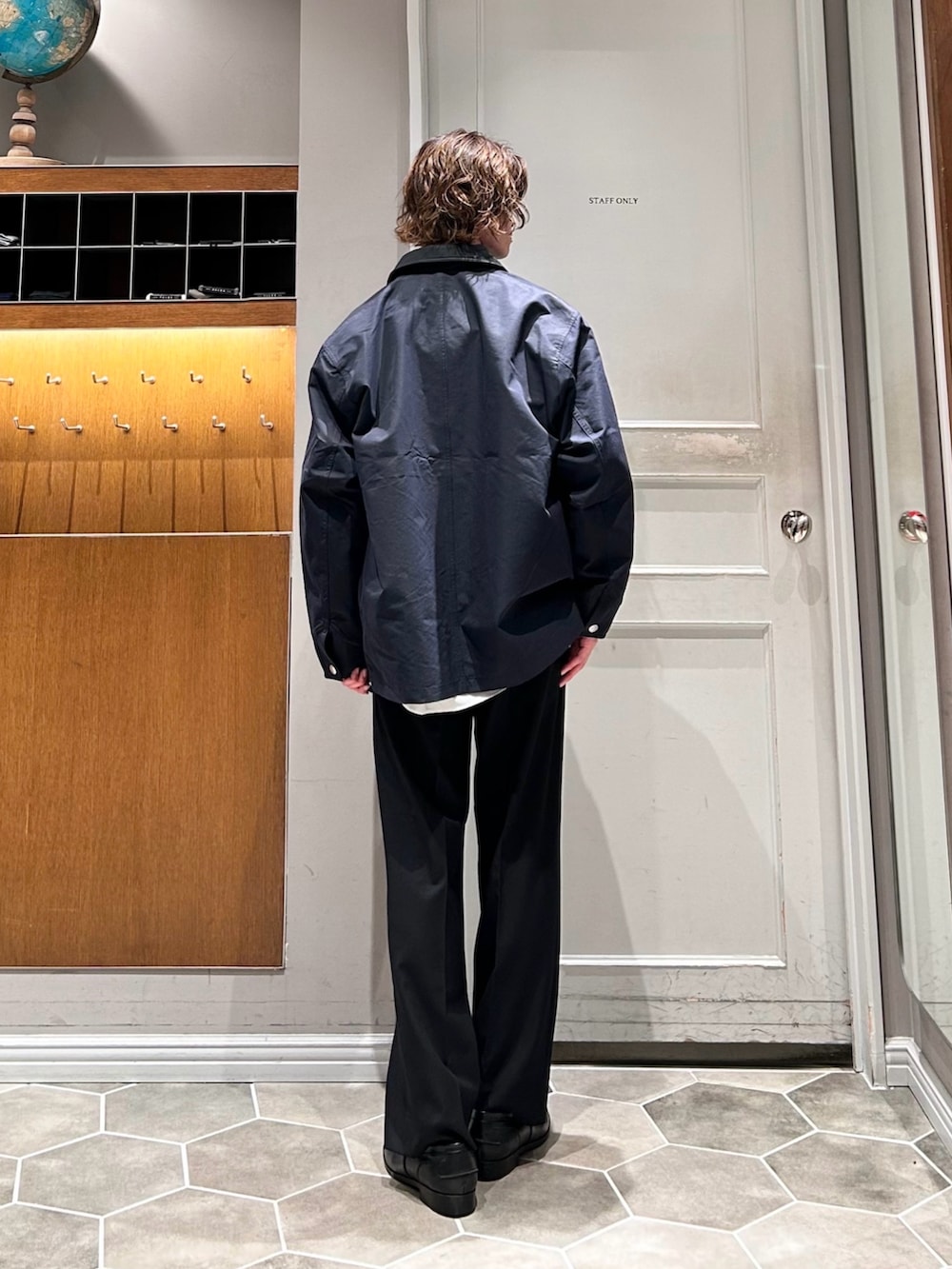 イエロー系のニット/セーター、ブルー系のその他アウター、ブラック系のローファーを着用したメンズの春コーディネートの3枚目の写真