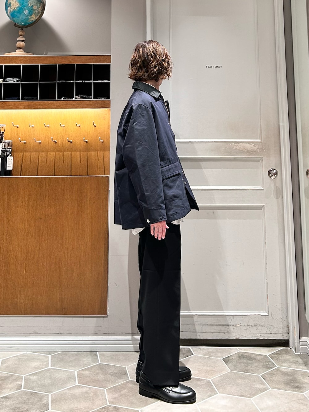 イエロー系のニット/セーター、ブルー系のその他アウター、ブラック系のローファーを着用したメンズの春コーディネートの2枚目の写真