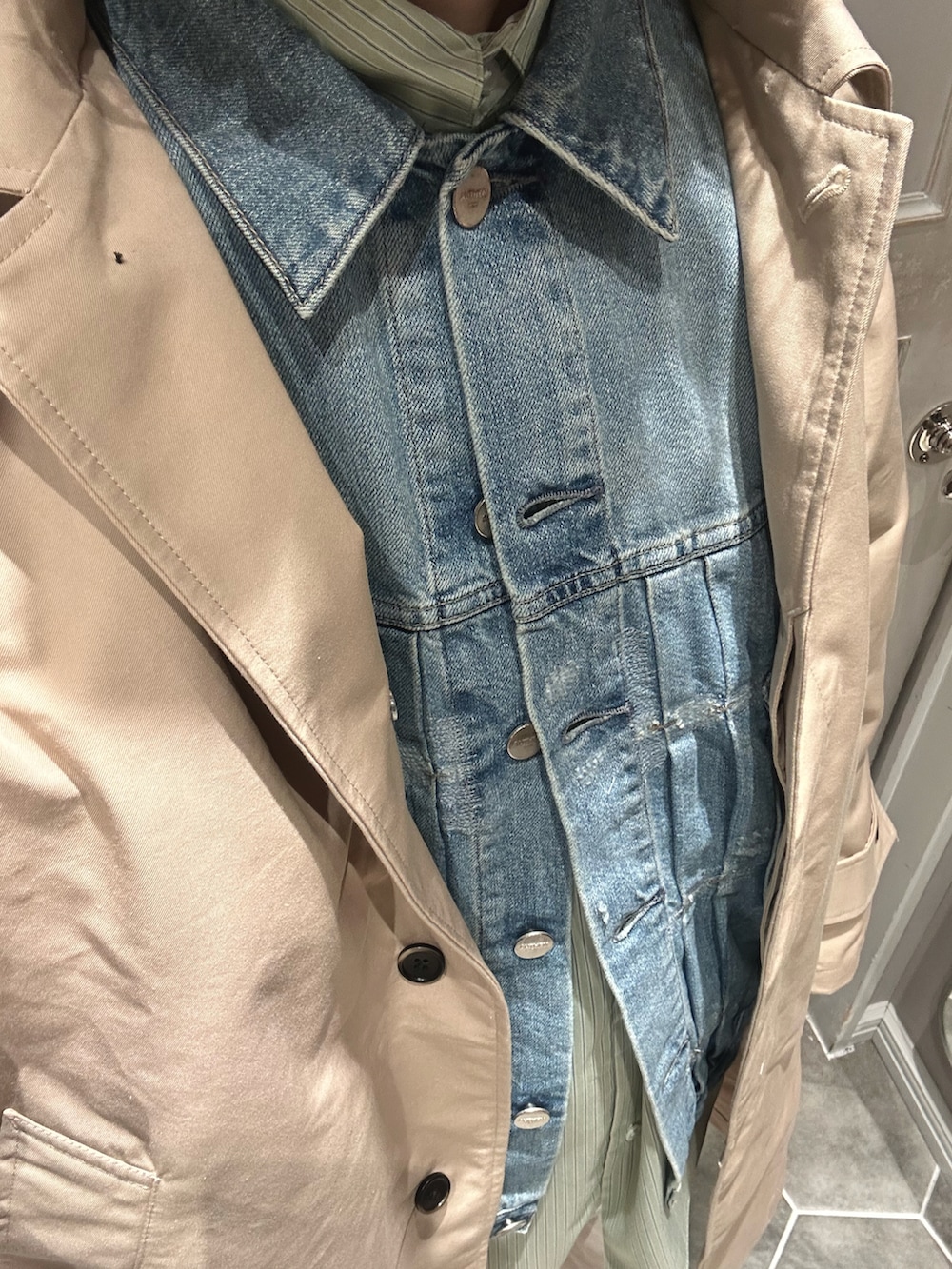 ベージュ系のステンカラーコート、ホワイト系のチノパンツ、ブラック系のローファーを着用したメンズの春コーディネートの5枚目の写真