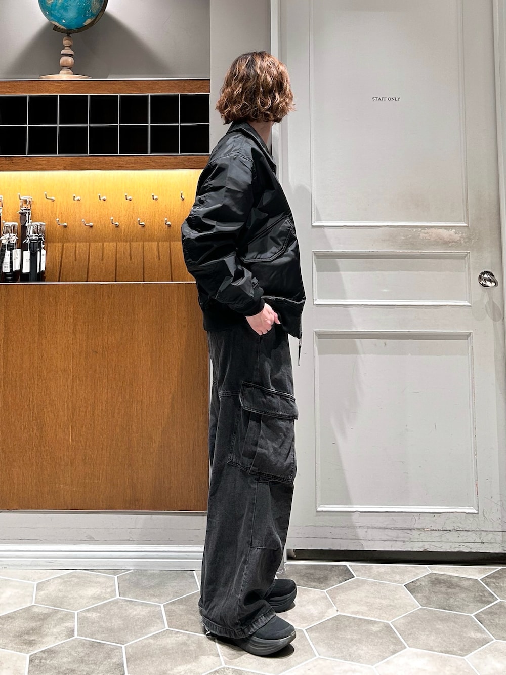 ブラック系のカーゴパンツ、ブラック系のブルゾン、ブラック系のスニーカーを着用したメンズの春コーディネートの2枚目の写真