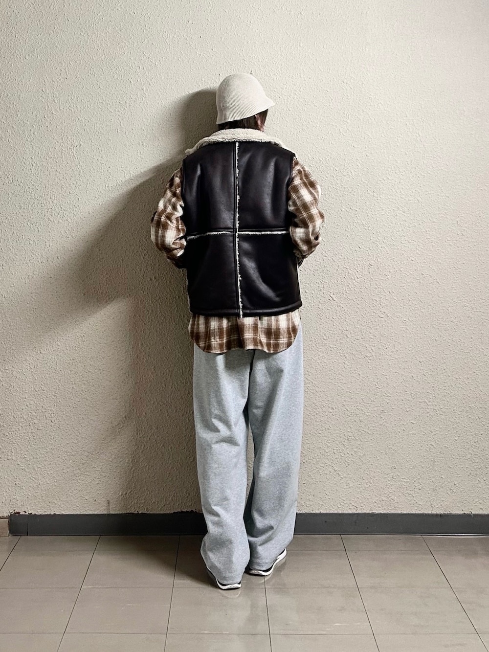 ブラウン系のブルゾン、ブラウン系のベスト、グレー系のスウェットパンツを着用したメンズの春コーディネートの3枚目の写真