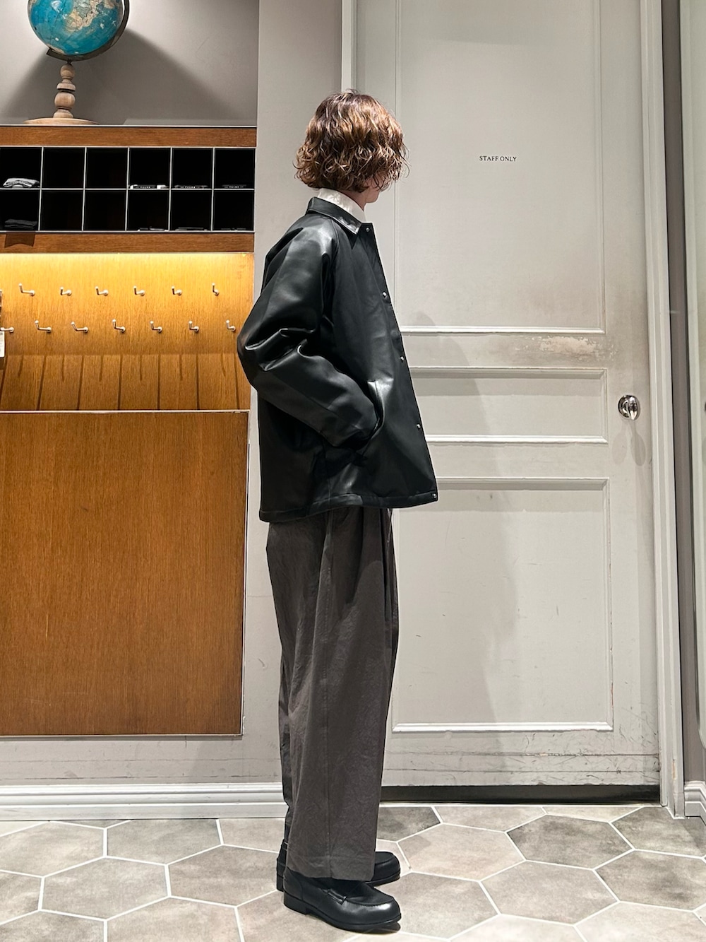 グリーン系のシャツ/ブラウス、ブラック系のブルゾン、ブラック系のローファーを着用したメンズの春コーディネートの2枚目の写真