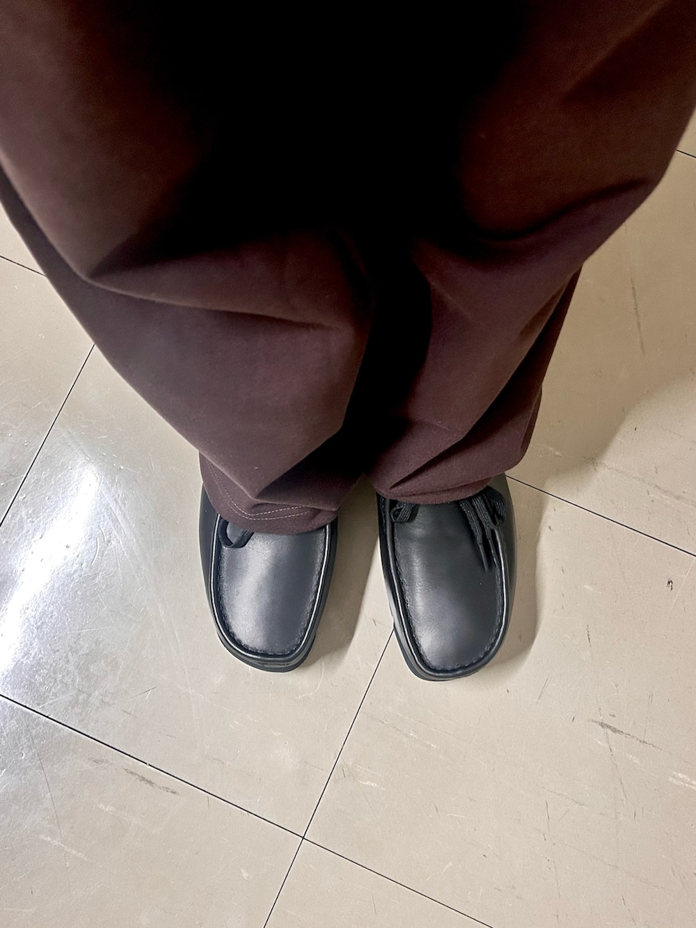 ブラウン系のその他アウター、ブラウン系のスウェットパンツ、ブラック系のハンドバッグを着用したメンズの春コーディネートの4枚目の写真