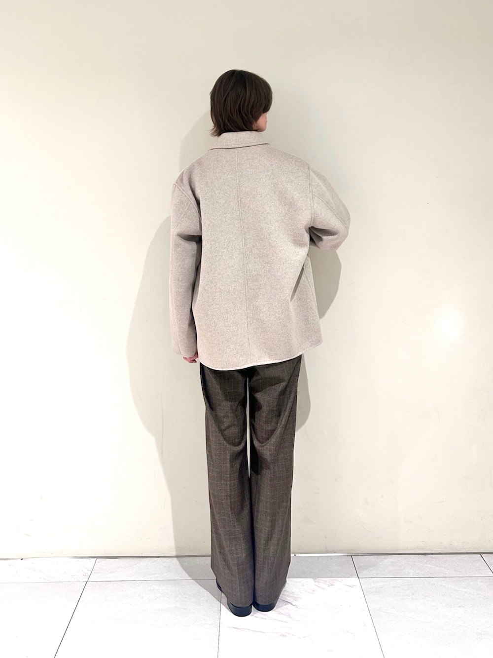 ブラック系のドレスシューズ、ベージュ系のカバーオール、グレー系のニット/セーターを着用したメンズの春コーディネートの3枚目の写真