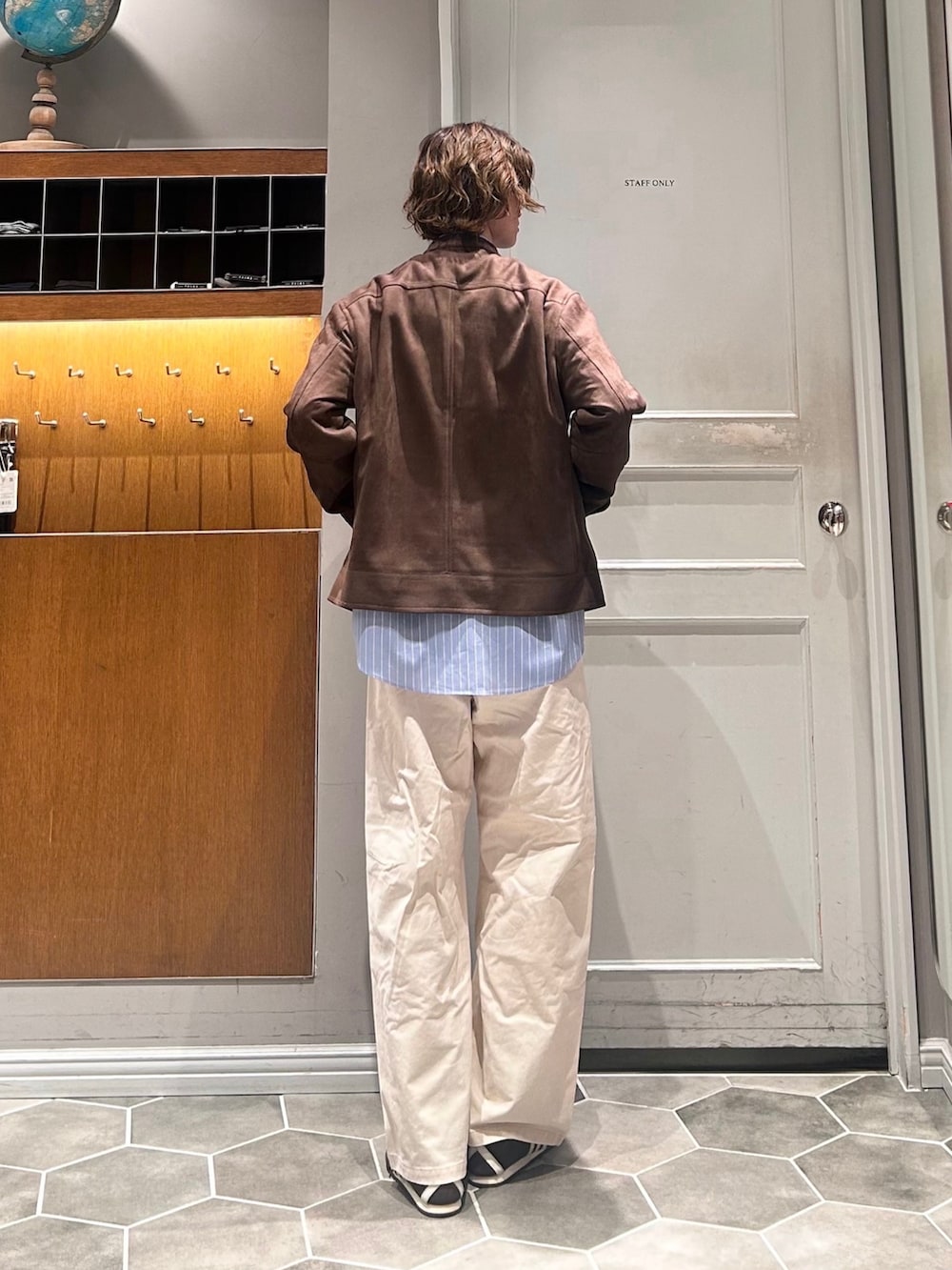 ホワイト系のチノパンツ、ブルー系のシャツ/ブラウス、ブラウン系のブルゾンを着用したメンズの春コーディネートの3枚目の写真