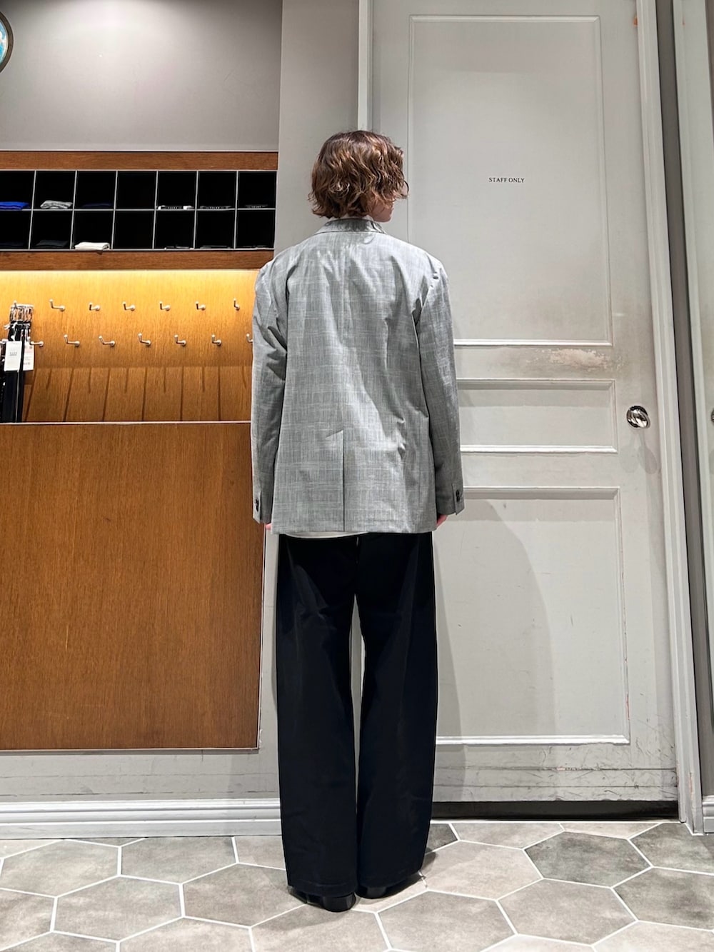 レッド系のニット/セーター、グレー系のテーラードジャケット、ブラック系のその他パンツを着用したメンズの春コーディネートの4枚目の写真