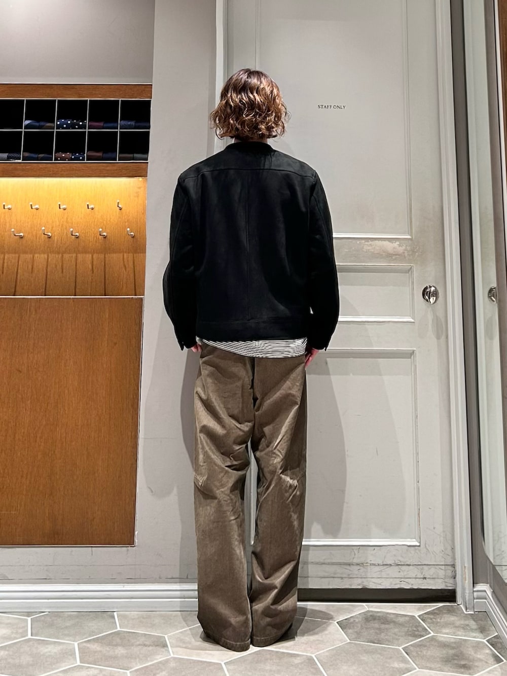ブラック系のブルゾン、グリーン系のチノパンツ、ブラック系のドレスシューズを着用したメンズの春コーディネートの3枚目の写真