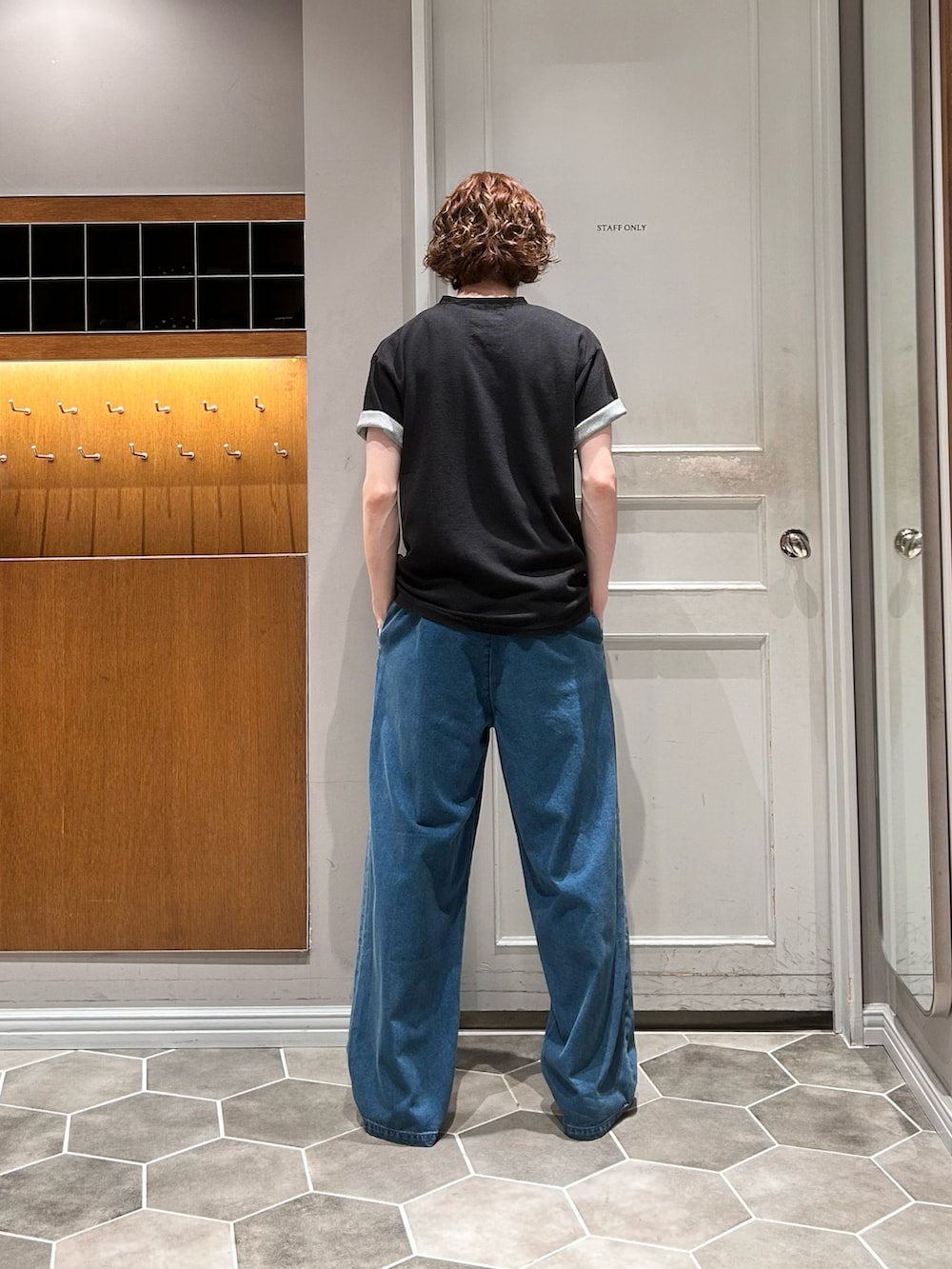 ブルー系のデニムパンツ、ブラック系のTシャツ/カットソー、ブラック系のローファーを着用したメンズの秋コーディネートの3枚目の写真