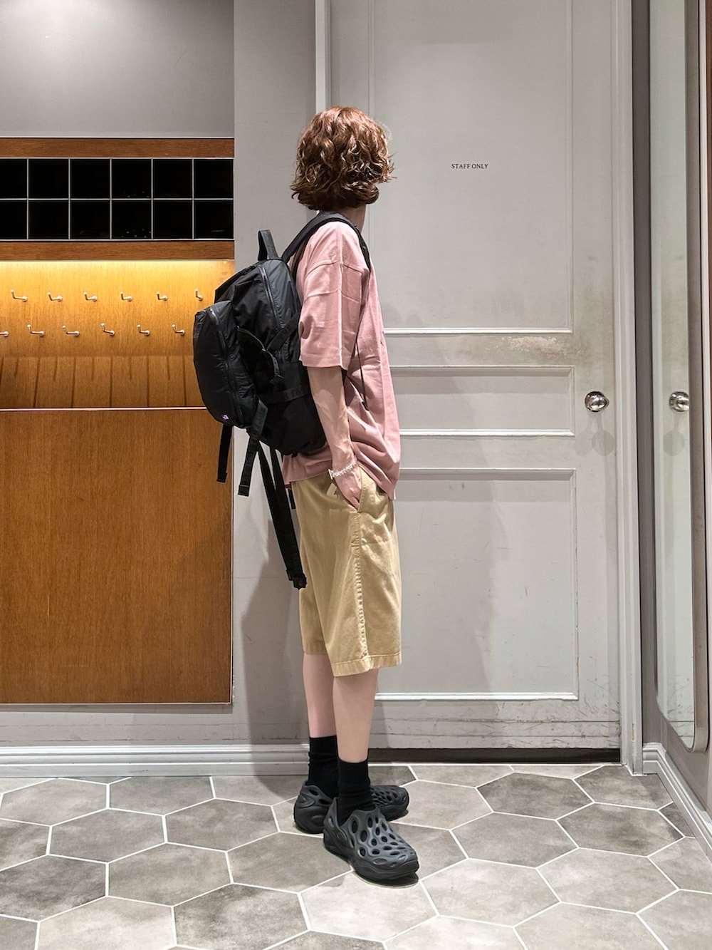 ブラック系のバックパック/リュック、ピンク系のTシャツ/カットソー、ブラック系のサンダルを着用したメンズの秋コーディネートの2枚目の写真