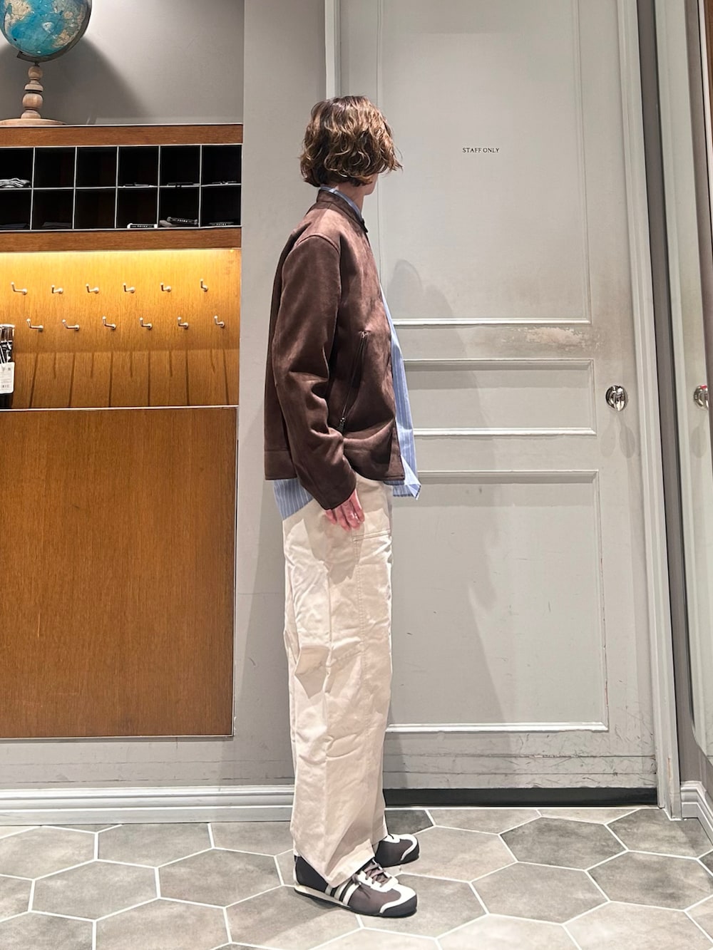 ホワイト系のチノパンツ、ブルー系のシャツ/ブラウス、ブラウン系のブルゾンを着用したメンズの春コーディネートの2枚目の写真