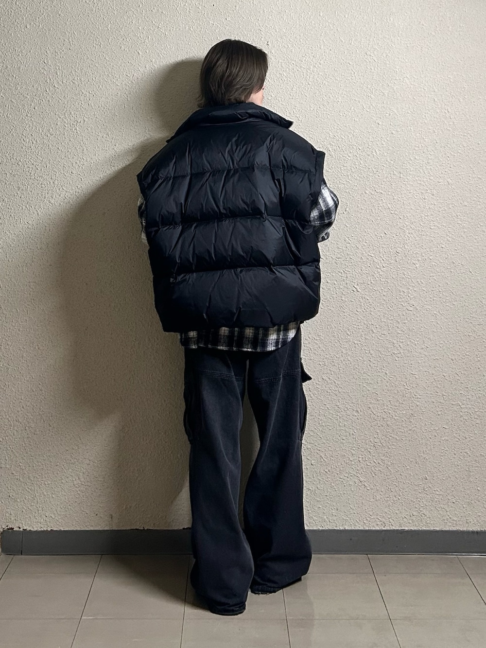 ブラック系のカーゴパンツ、ブラック系のダウンベスト、ブラウン系のブーツを着用したメンズの春コーディネートの3枚目の写真