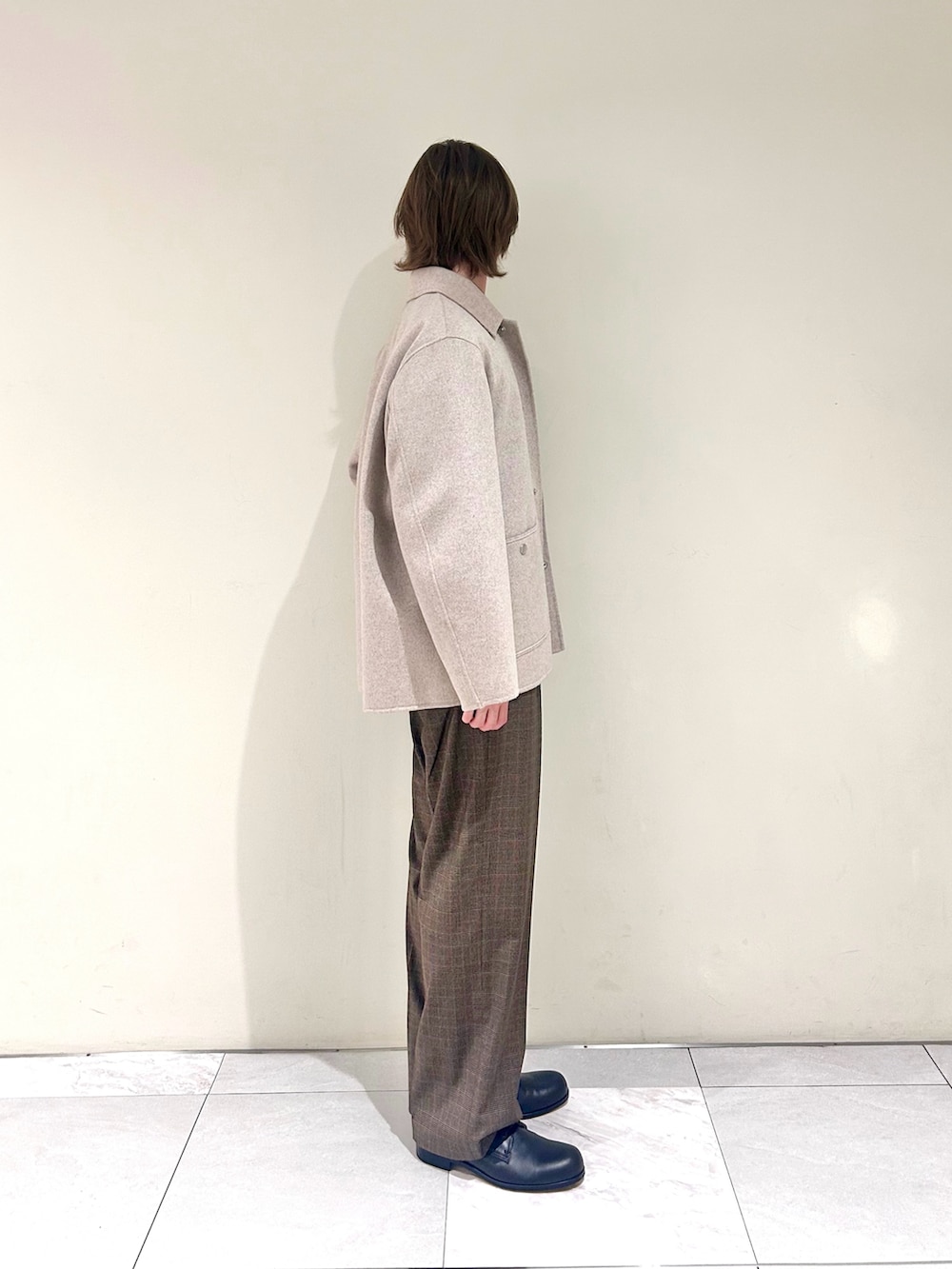 ブラック系のドレスシューズ、ベージュ系のカバーオール、グレー系のニット/セーターを着用したメンズの春コーディネートの2枚目の写真