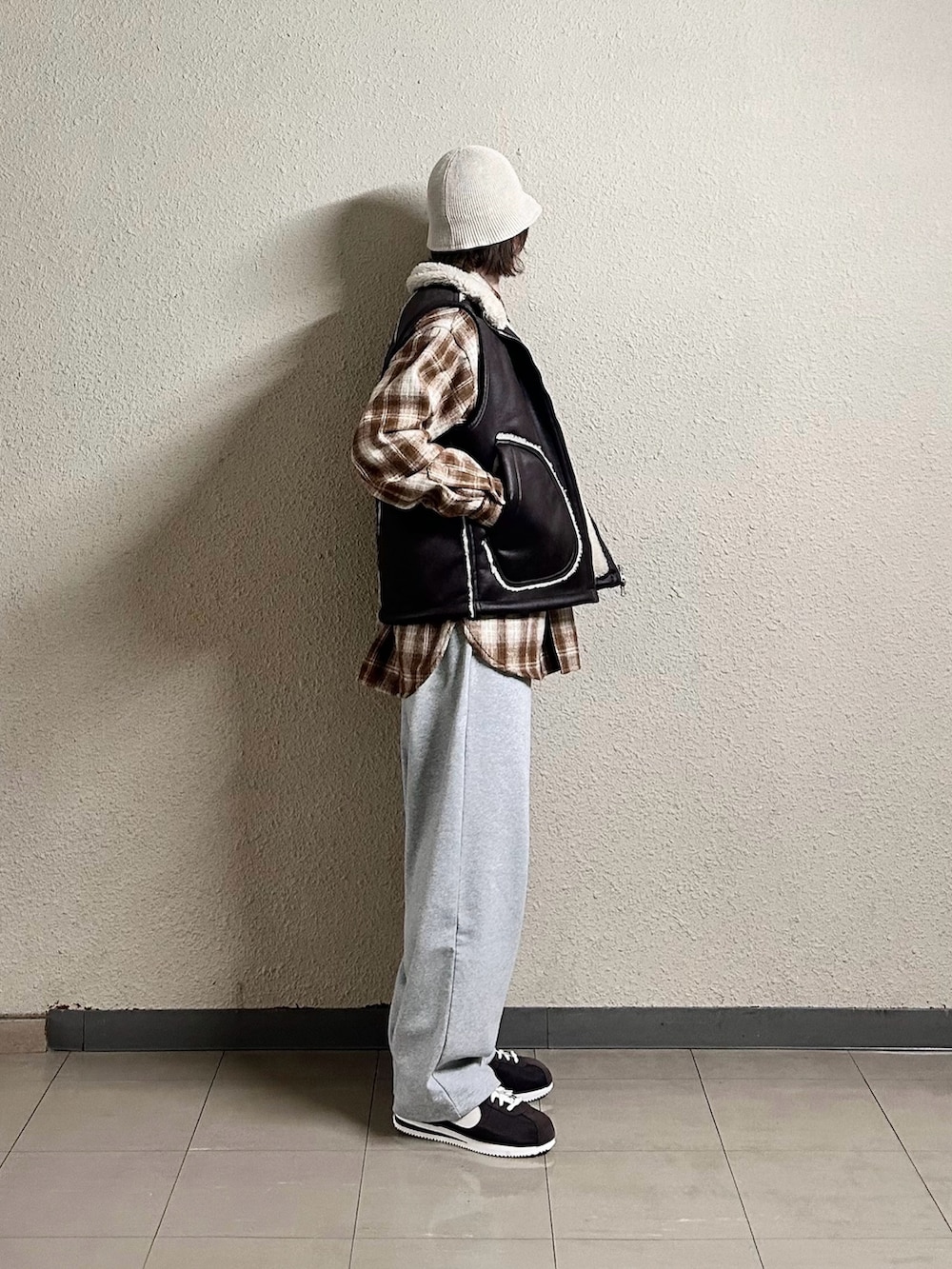 ブラウン系のブルゾン、ブラウン系のベスト、グレー系のスウェットパンツを着用したメンズの春コーディネートの2枚目の写真