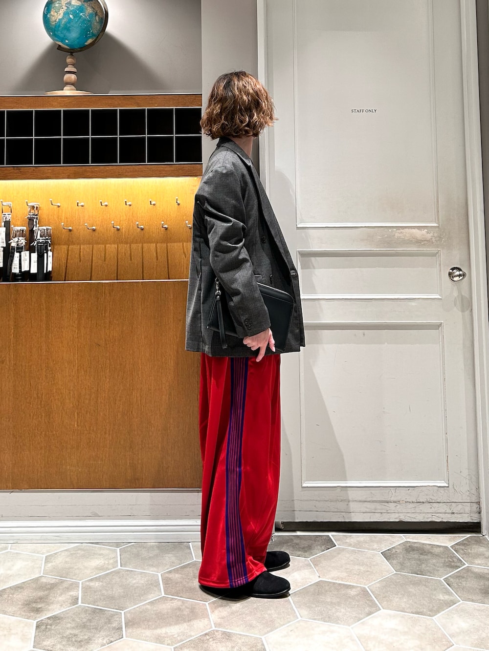 ブラック系のブーツ、レッド系のパンツを着用したメンズの春コーディネートの2枚目の写真