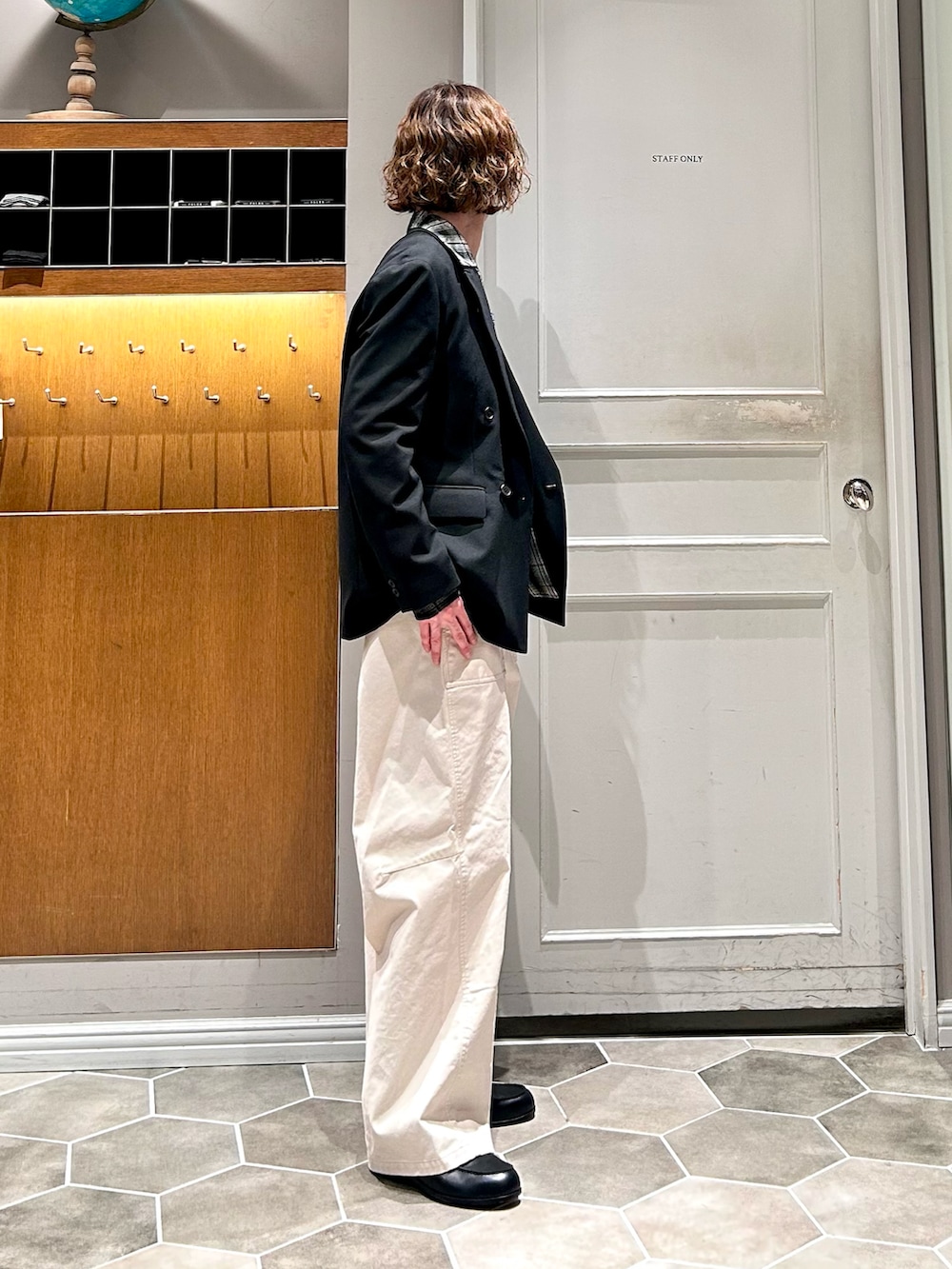 ブラック系のテーラードジャケット、ホワイト系のチノパンツを着用したメンズの春コーディネートの3枚目の写真