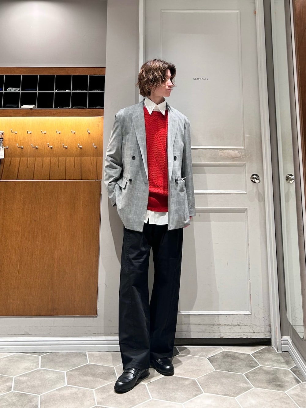 レッド系のニット/セーター、グレー系のテーラードジャケット、ブラック系のその他パンツを着用したメンズの春コーディネートの2枚目の写真