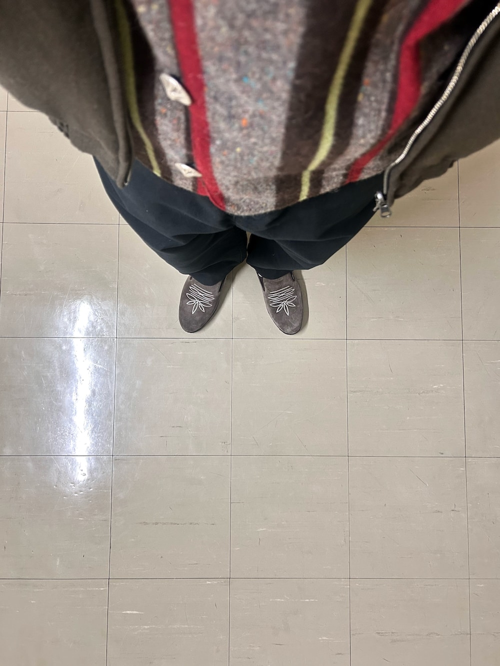 レッド系のベスト、ブラック系のパンツ、ブラウン系のシューズを着用したメンズの春コーディネートの5枚目の写真