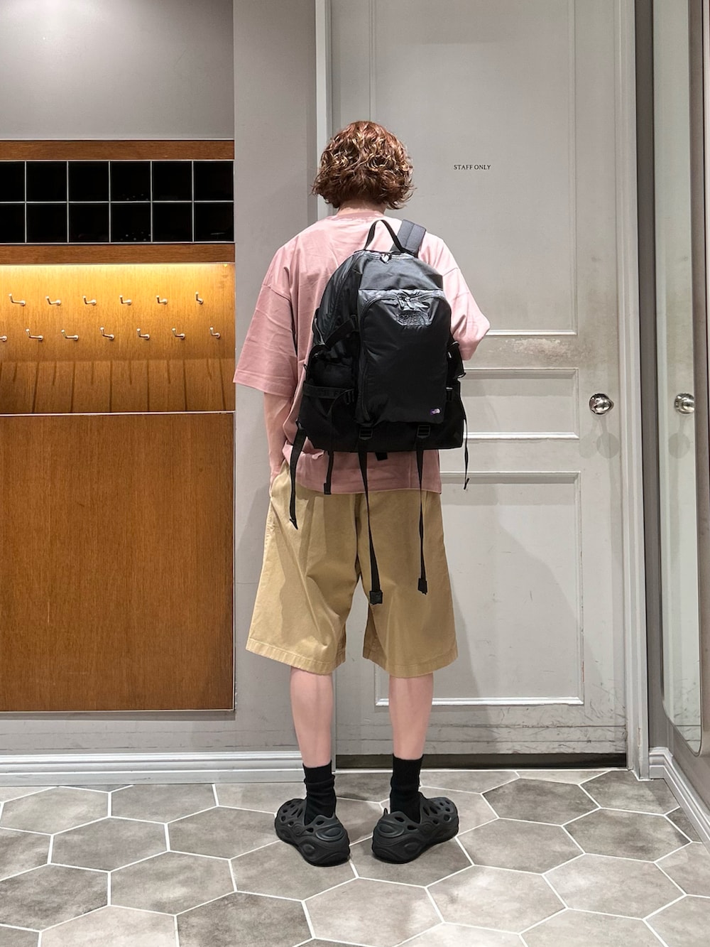 ブラック系のバックパック/リュック、ピンク系のTシャツ/カットソー、ブラック系のサンダルを着用したメンズの秋コーディネートの3枚目の写真