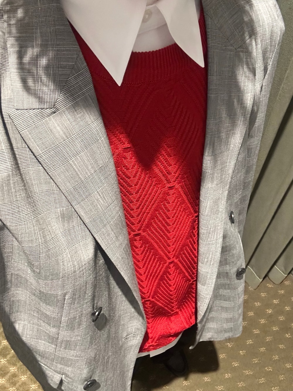 レッド系のニット/セーター、グレー系のテーラードジャケット、ブラック系のその他パンツを着用したメンズの春コーディネートの5枚目の写真