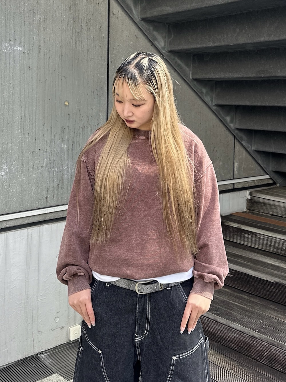 ブラウン系のスウェット、ブラック系のデニムパンツ、ホワイト系のTシャツ/カットソーを着用したレディースの秋コーディネートの4枚目の写真