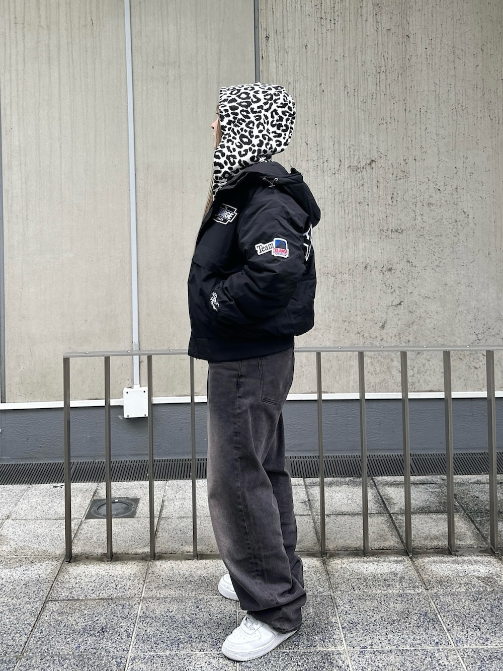 ホワイト系のパーカー、ブラック系のブルゾン、ブラウン系のデニムパンツを着用したレディースの秋コーディネートの3枚目の写真