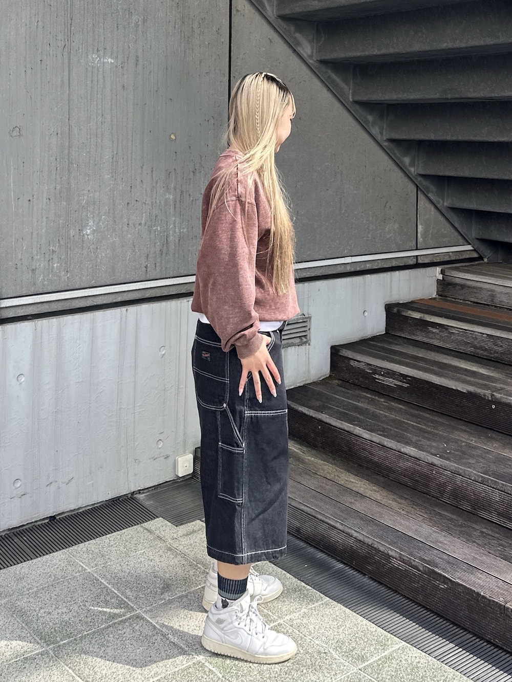 ブラウン系のスウェット、ブラック系のデニムパンツ、ホワイト系のTシャツ/カットソーを着用したレディースの秋コーディネートの2枚目の写真