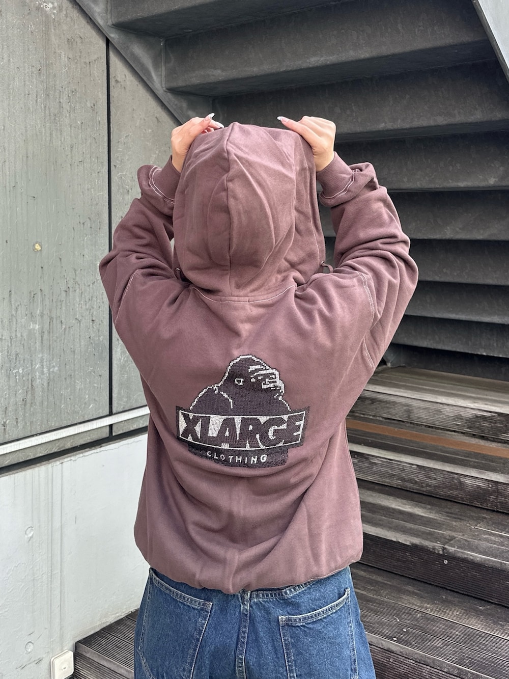 ピンク系のTシャツ/カットソー、ブラウン系のパーカー、ブルー系のデニムパンツを着用したレディースの秋コーディネートの4枚目の写真