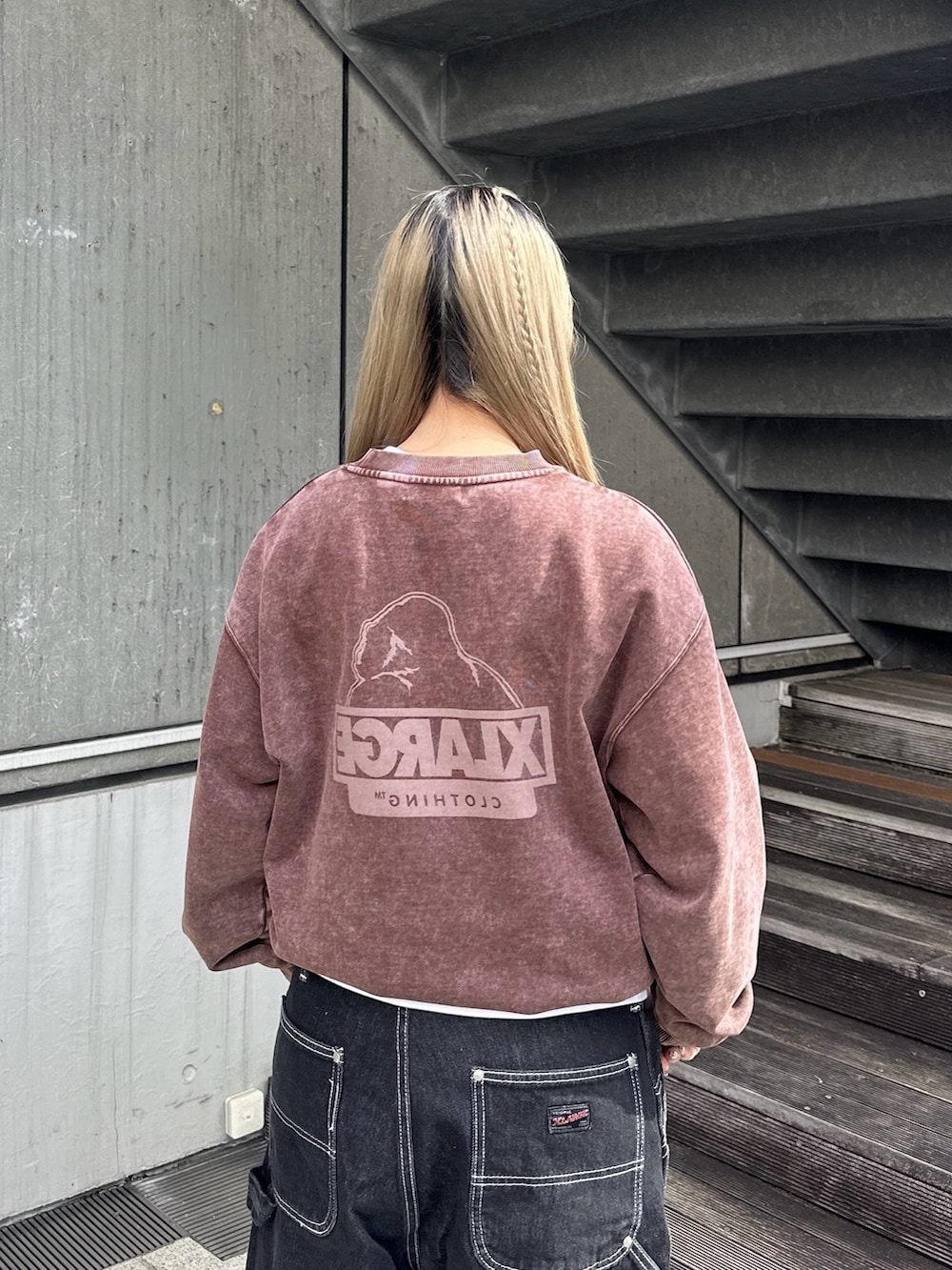 ブラウン系のスウェット、ブラック系のデニムパンツ、ホワイト系のTシャツ/カットソーを着用したレディースの秋コーディネートの5枚目の写真