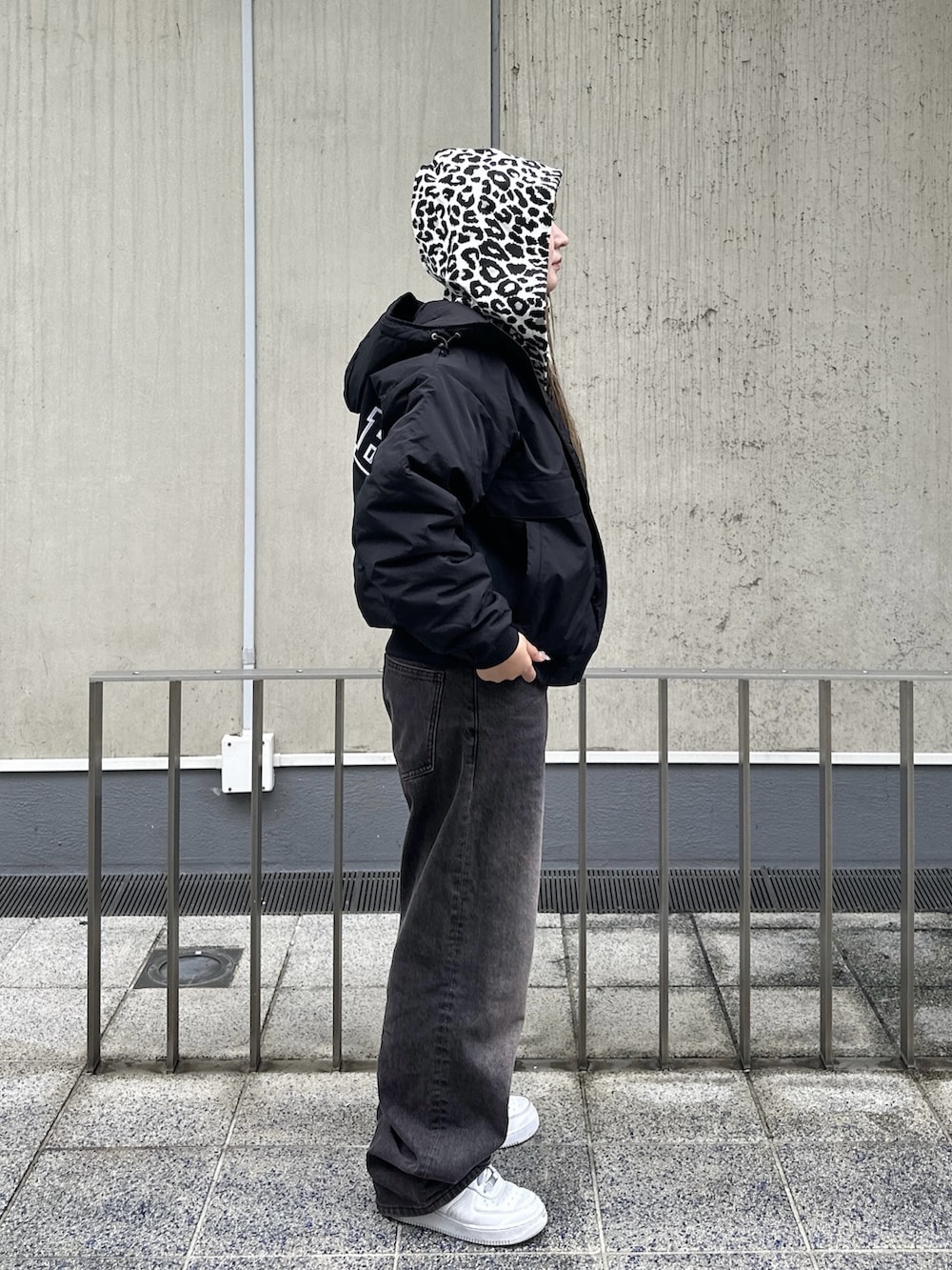ホワイト系のパーカー、ブラック系のブルゾン、ブラウン系のデニムパンツを着用したレディースの秋コーディネートの5枚目の写真