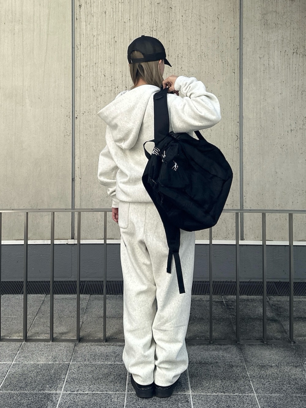 グレー系のパーカー、グレー系のスウェットパンツ、ブラック系のバックパック/リュックを着用したレディースの秋コーディネートの2枚目の写真