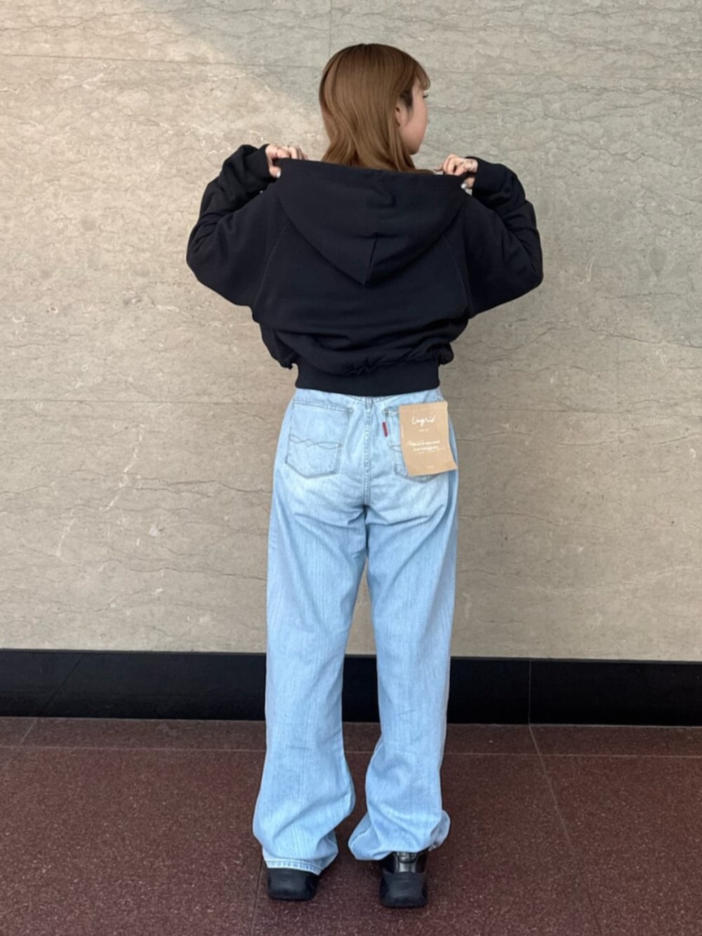 ブルー系のデニムパンツ、グレー系のパーカーを着用したレディースの春コーディネートの3枚目の写真