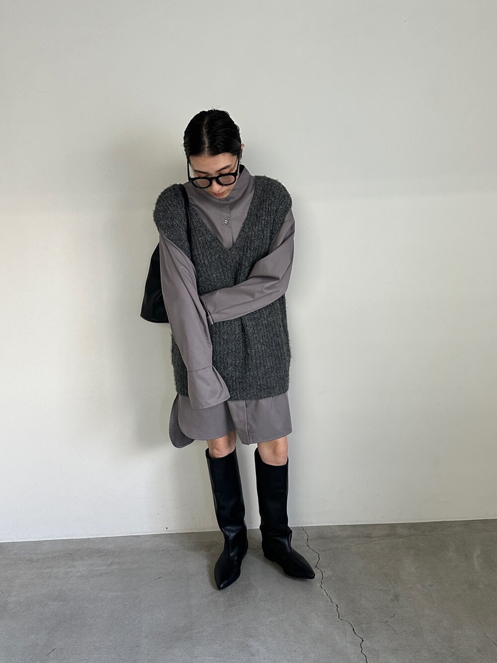 グレー系のシャツ/ブラウス、グレー系のベスト、ブラック系のブーツを着用したレディースの冬コーディネートの4枚目の写真